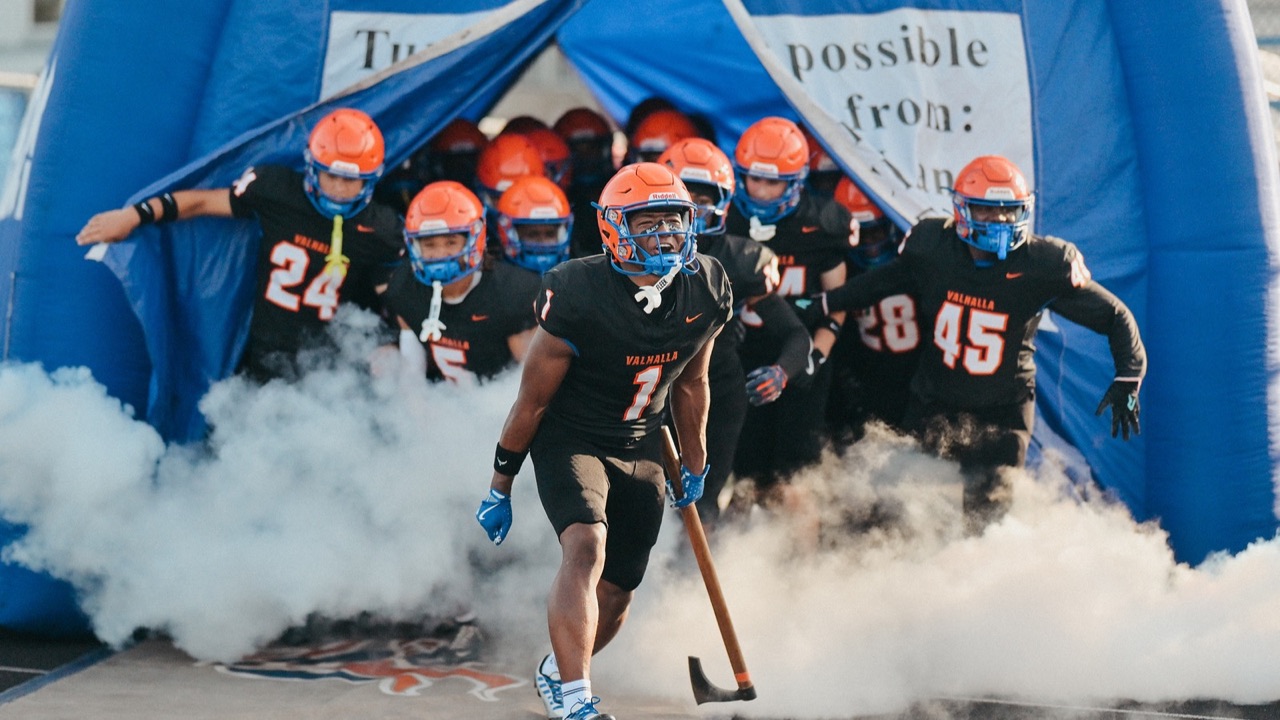 West Orange Warriors football players running onto the field on game day